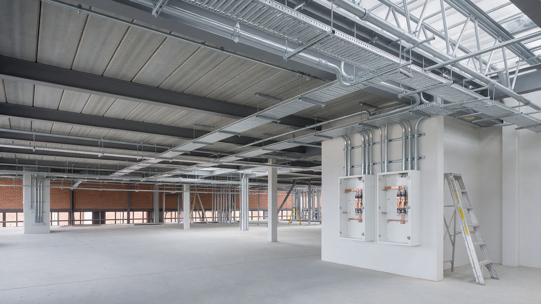 New-build commercial floor with cable trays and distribution boards